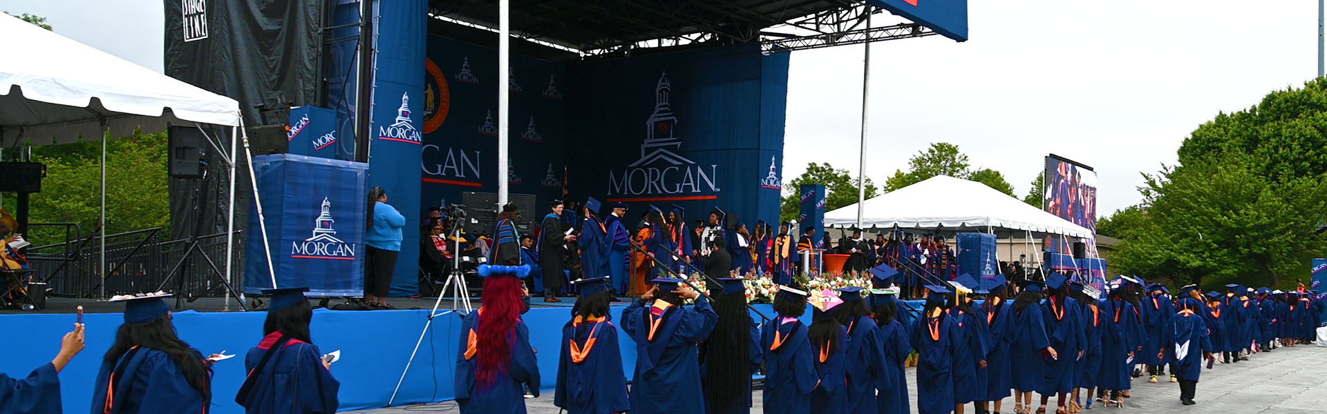 graduates walking towards stage at spring commencement ceremonies